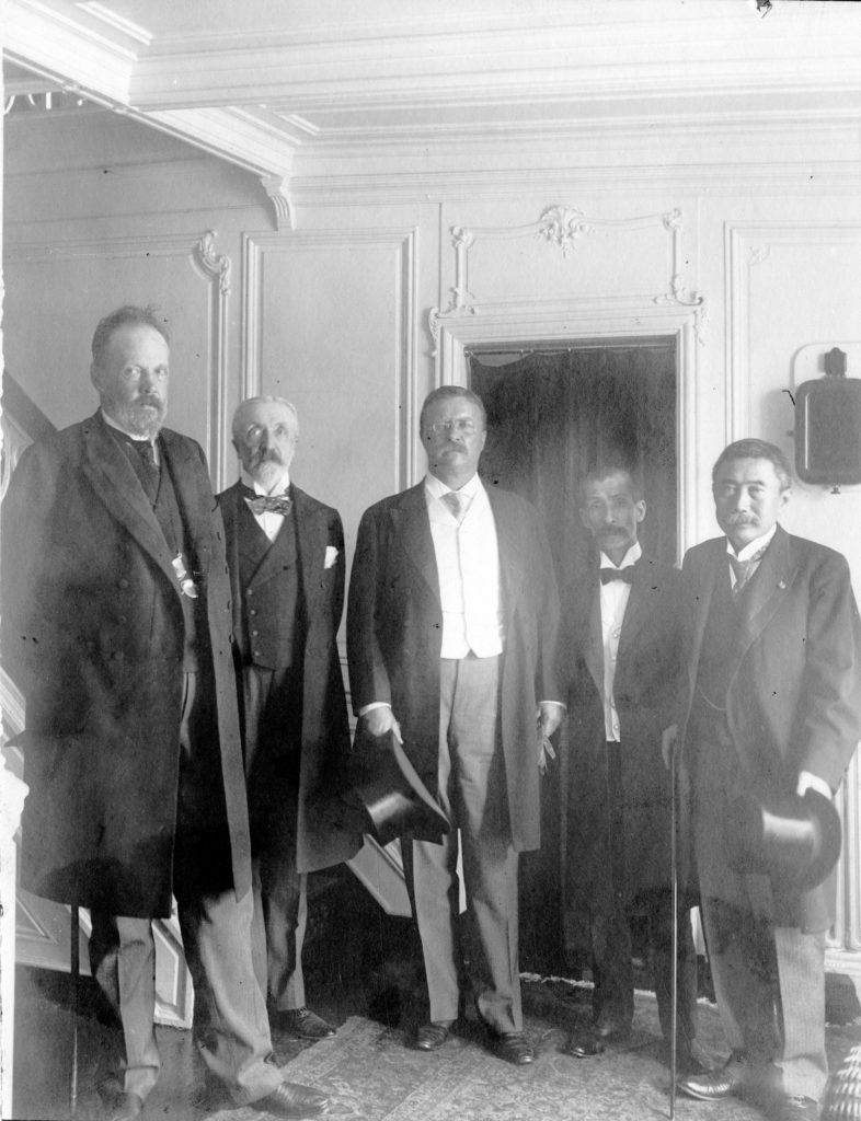 Count Sergei Witte standing with Russian Ambassador to the US Baron Roman R. Rosen, Theodore Roosevelt, Foreign Minister Marquis Jutaro Komura, and Japanese Ambassador to the US Baron Kogoro Takahira, aboard the presidential yacht in Oyster Bay, New York, August 1905