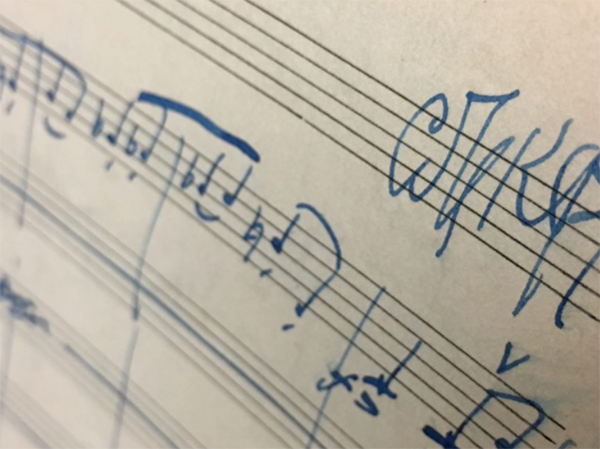 Image of music handwritten on staff. Links to event info.