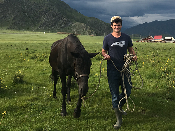 Tyler Adkins with horse. Image leads to a postdoc spotlight.