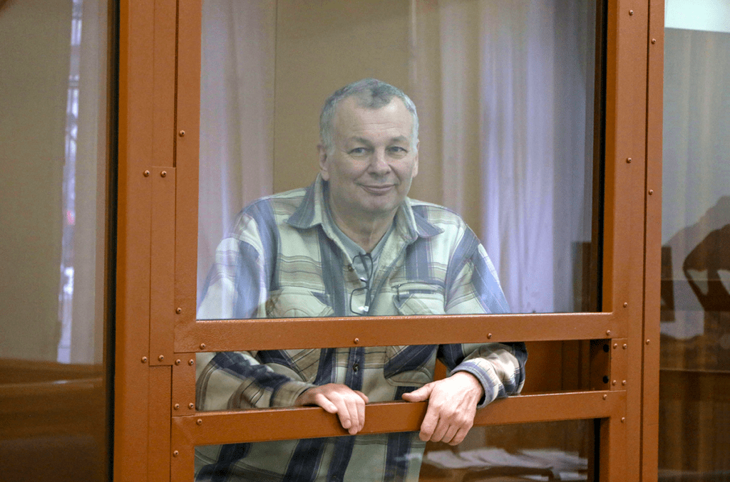 Photograph of Mikhail Krieger behind glass.