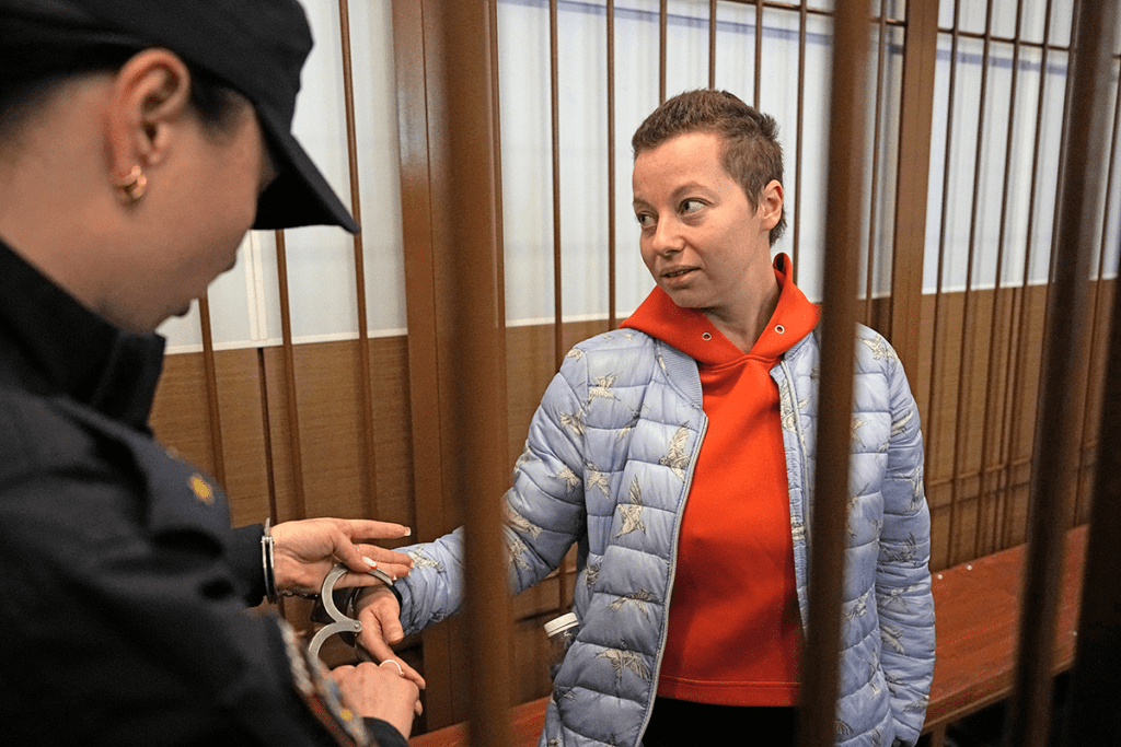 Woman with short haircut and another woman putting on or removing handcuffs from her wrists