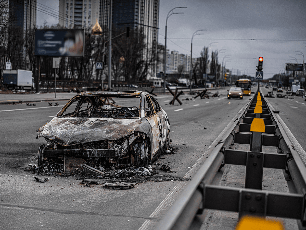 Remains of a burnt car in the middle of the road.