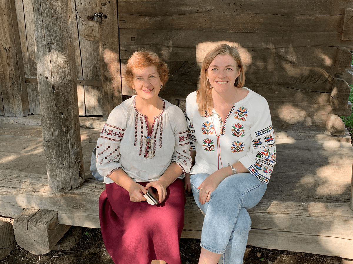 Photo of two women wearing vyshyvankas, traditional Ukrainian embroidered shirts.
