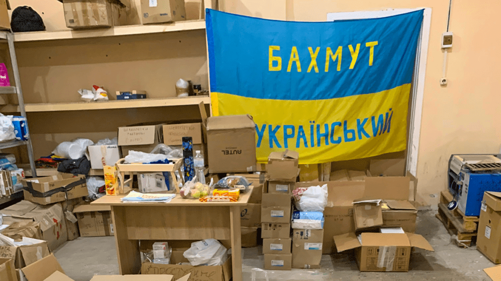 Boxes in a wearhouse with Ukrainian flag hanging behind them